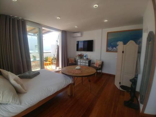 a bedroom with a bed and a table and a balcony at BEACH ATTIC in Zahara de los Atunes