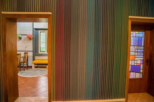 a room with a wall covered in colorful stripes at Our Way Guest House & Hostel in Shkodër