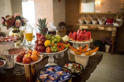 a table with many plates of fruit on it at Hotel da Praia in Vila Velha