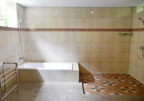 a bathroom with a bath tub and a shower at Villa with private pool at Villa Nirvana Ubud in Ubud