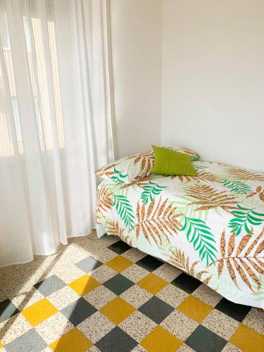 a bed sitting in a room next to a window at La casetta di nonno Vittorio in Albissola Marina