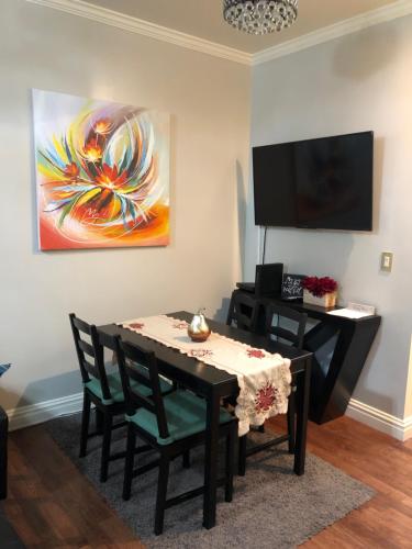 un comedor con mesa, sillas y una pintura en Modern 2 Bedroom Apartment NYC, en Nueva York