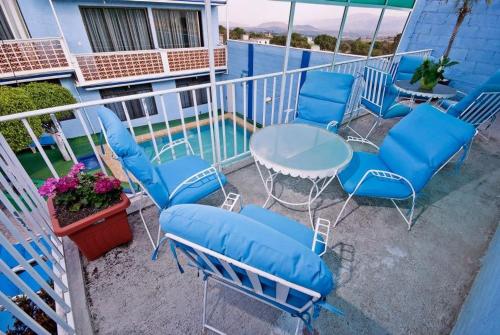 balcón con sillas azules, mesa y piscina en Casa de Huéspedes May, en Ixtapan de la Sal