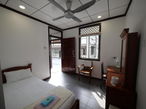 a bedroom with a bed and a desk and a chair at Hickory Penang Hill in George Town