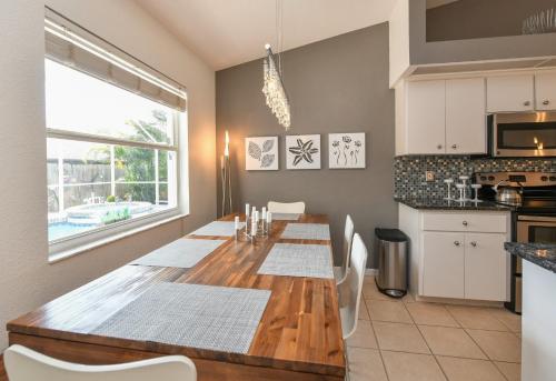 a kitchen with a wooden table with white chairs at Contemporary Pool Villa I - Pool & Jacuzzi - Nearby Beach in Venice