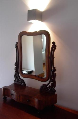 a mirror on a table with a light on it at Quinta da Lapa in Manique do Intendente