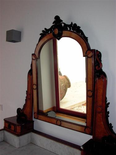 a mirror with a wooden frame on a wall at Quinta da Lapa in Manique do Intendente