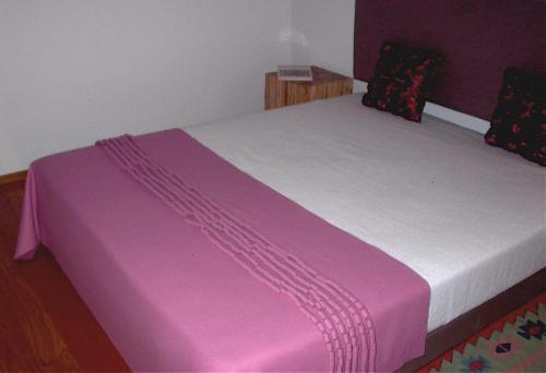 a pink and white bed in a room at Quinta da Lapa in Manique do Intendente