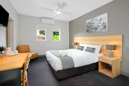 Kingsgrove Hotel في سيدني: غرفة نوم مع سرير ومكتب ومكتب