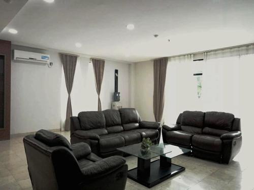 a living room with two leather couches and a coffee table at The Centro Hotel & Residence By Orchardz in Batam Center
