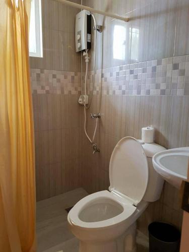 a bathroom with a toilet and a sink at Jelly's Haven Resort in Bantayan Island