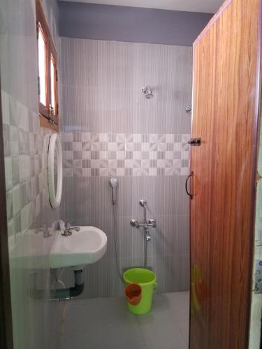 een badkamer met een wastafel, een toilet en een spiegel bij Elim Vacation Villa in Tarangambādi