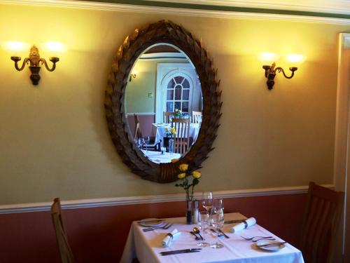 a dining room with a table with a mirror at Trigony Hotel and Garden Spa in Closeburn