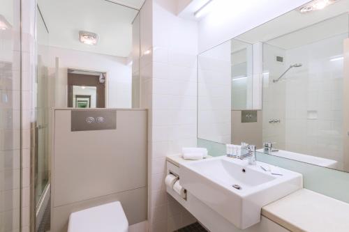 a bathroom with a sink, toilet, and bathtub at Best Western Plus Launceston in Launceston
