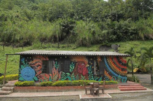 a small house with a painting on the side of it at HOTEL LA SELVA Reserva in La Vega