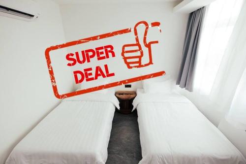a sign that says super deal in a room with two beds at White Loft Hotel in Melaka