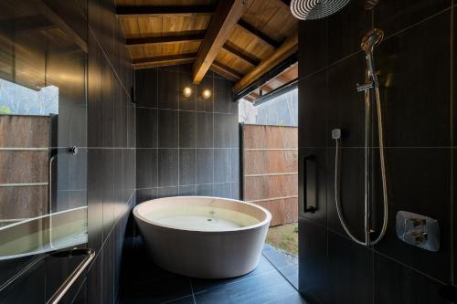 a bath tub in a bathroom with a shower at Nazuna Kyoto Gosho in Kyoto