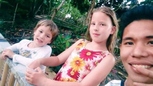 a boy and a girl standing next to a man at Villa catalina Bora 2 Resort in Nabas