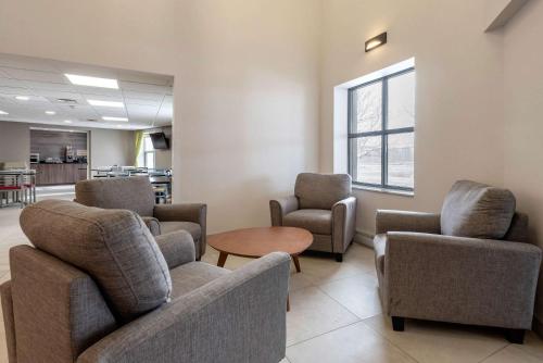 a waiting room with chairs and a table at Quality Suites in Quebec City