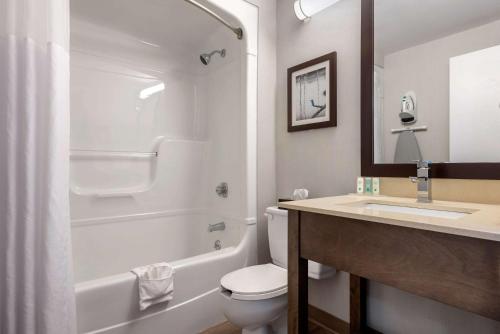 a bathroom with a toilet and a sink and a shower at Quality Suites in Quebec City