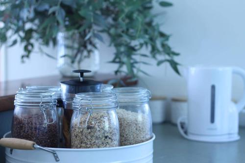 Seaview Cottage في Mokau: حاوية مليئة بجرار من البذور على المنضدة