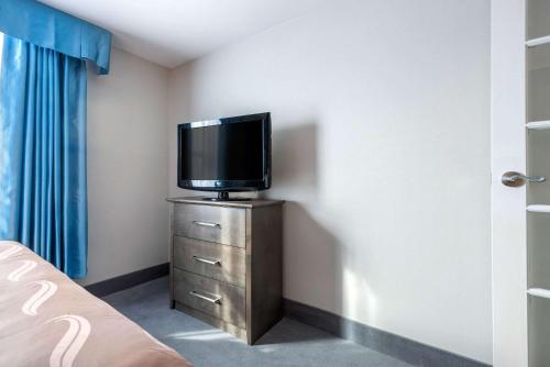 a tv sitting on top of a dresser in a room at Quality Suites in Quebec City