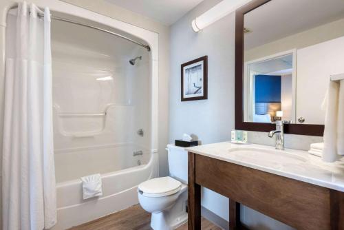 a bathroom with a toilet and a sink and a shower at Quality Suites in Quebec City
