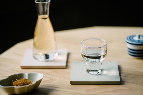 a table with a glass of water and a bowl of food at Nazuna Kyoto Gosho in Kyoto