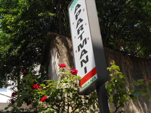 a sign for a gas station with red roses at Apartments & Hostel Zdrava Hrana in Mostar