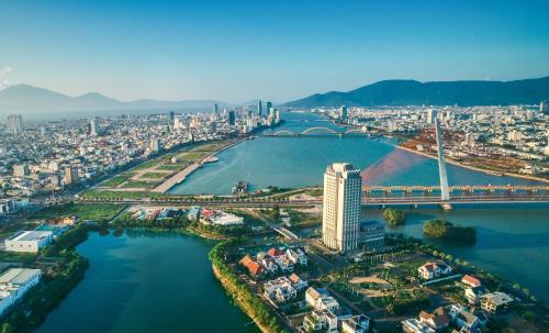 an aerial view of a city with a bridge over a river at Grand Mercure Danang in Da Nang