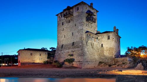 an old castle is lit up at night at Pansion Katerina in Ouranoupoli