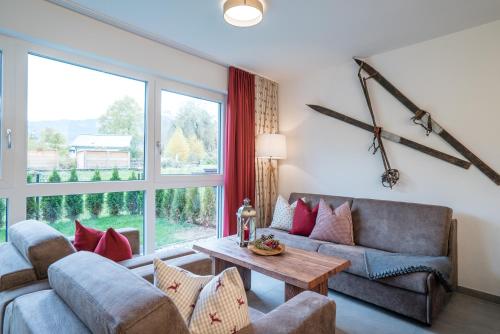 a living room with a couch and a table at Village Park Suites by VAYA inklusive Zell am See Kaprun Sommer Karte in Zell am See