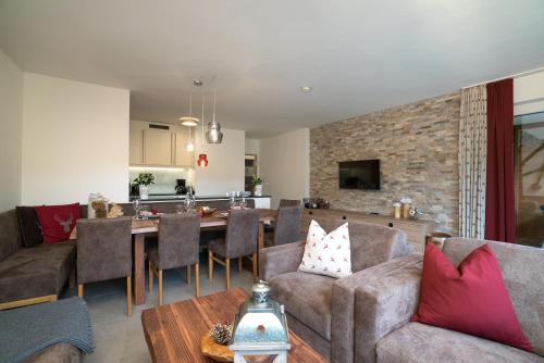 a living room with a couch and a table at Village Park Suites by VAYA inklusive Zell am See Kaprun Sommer Karte in Zell am See