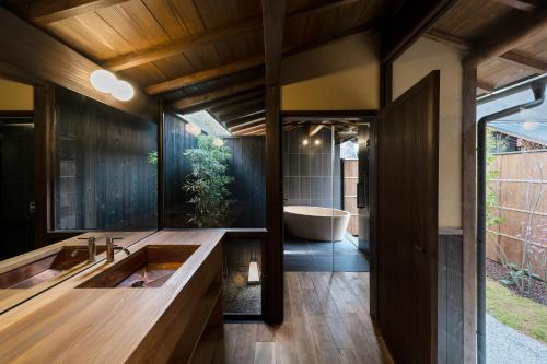 a bathroom with a large sink and a bath tub at Nazuna Kyoto Gosho in Kyoto