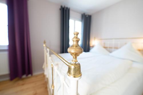 a bed with a gold post in a bedroom at Hotel Alexander in Wiesbaden