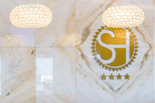 a chandelier and a sign on a marble wall at Sun Hall Hotel in Larnaka
