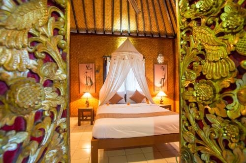 a bedroom with a bed with a canopy at Pondok Permata Homestay in Ubud