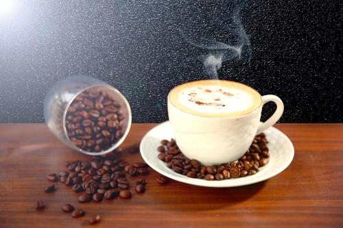 a cup of coffee on a table with coffee beans at Comfort Inn Benares in Varanasi