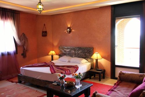 a bedroom with a bed and a table and a couch at Palais Dar Ouladna in Marrakesh