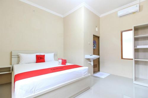 um quarto com uma cama e um lavatório em RedDoorz near Balekambang City Park em Surakarta