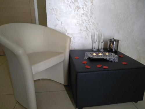 a table with a white chair and a table with a black table sidx sidx sidx at B&B Vistamareblu in San Foca