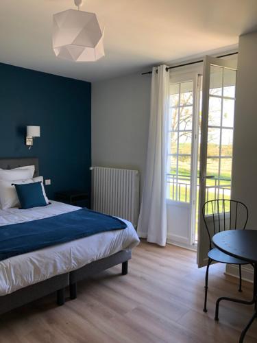 1 dormitorio con cama, mesa y ventana en LA FERME D'AIGUROLLES, en Saint-Maur