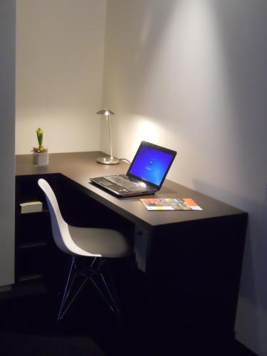 a laptop computer sitting on a desk with a chair at Fletcher Hotel-Restaurant Parkstad- Zuid Limburg in Kerkrade