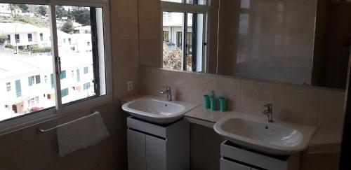 a bathroom with two sinks and a mirror and a window at Villa SCIROCCO Madeira - Ocean View in Machico