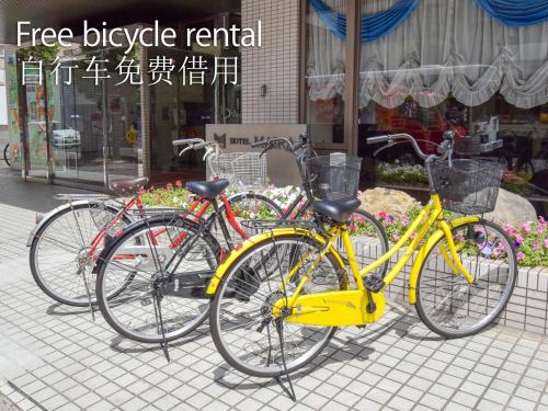 three bikes are parked in front of a store at Hotel Maira in Okayama