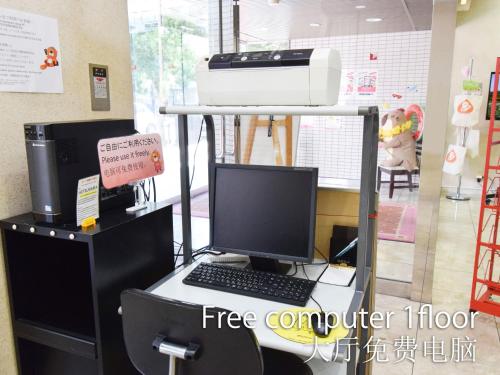 a computer on a desk with a keyboard and a printer at Hotel Maira in Okayama