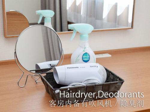 a mirror and a hair dryer and a blow dryer at Hotel Maira in Okayama