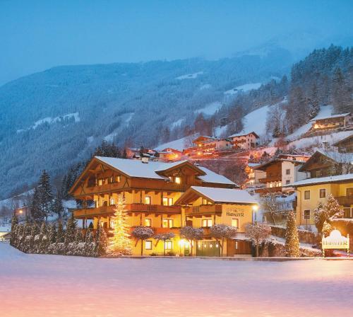 a large building with snow on it in the mountains at Villa Haidacher Relax & Lifestyle Apartments in Zell am Ziller