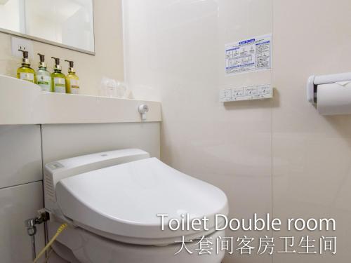 a bathroom with a toilet and some bottles of wine at Hotel Maira in Okayama