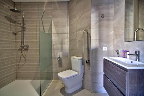 a bathroom with a toilet and a shower and a sink at Apartamentos Arenal in Jerez de la Frontera
